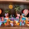 Scene of wooden toys featuring mermaids, and sea creatures by the ocean side in an array of colors